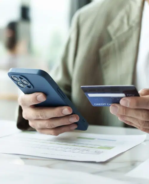 man holding a credit card and phone